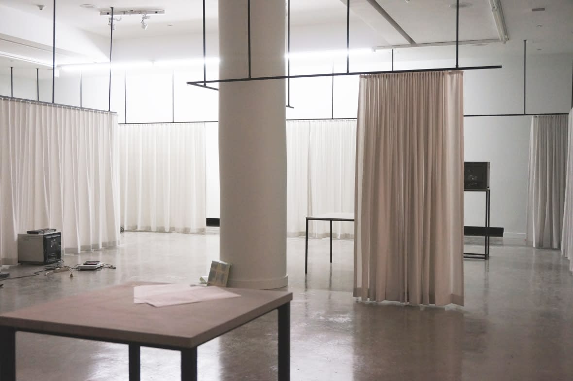 Exhibition installation featuring TV and tabletop surrounded by c